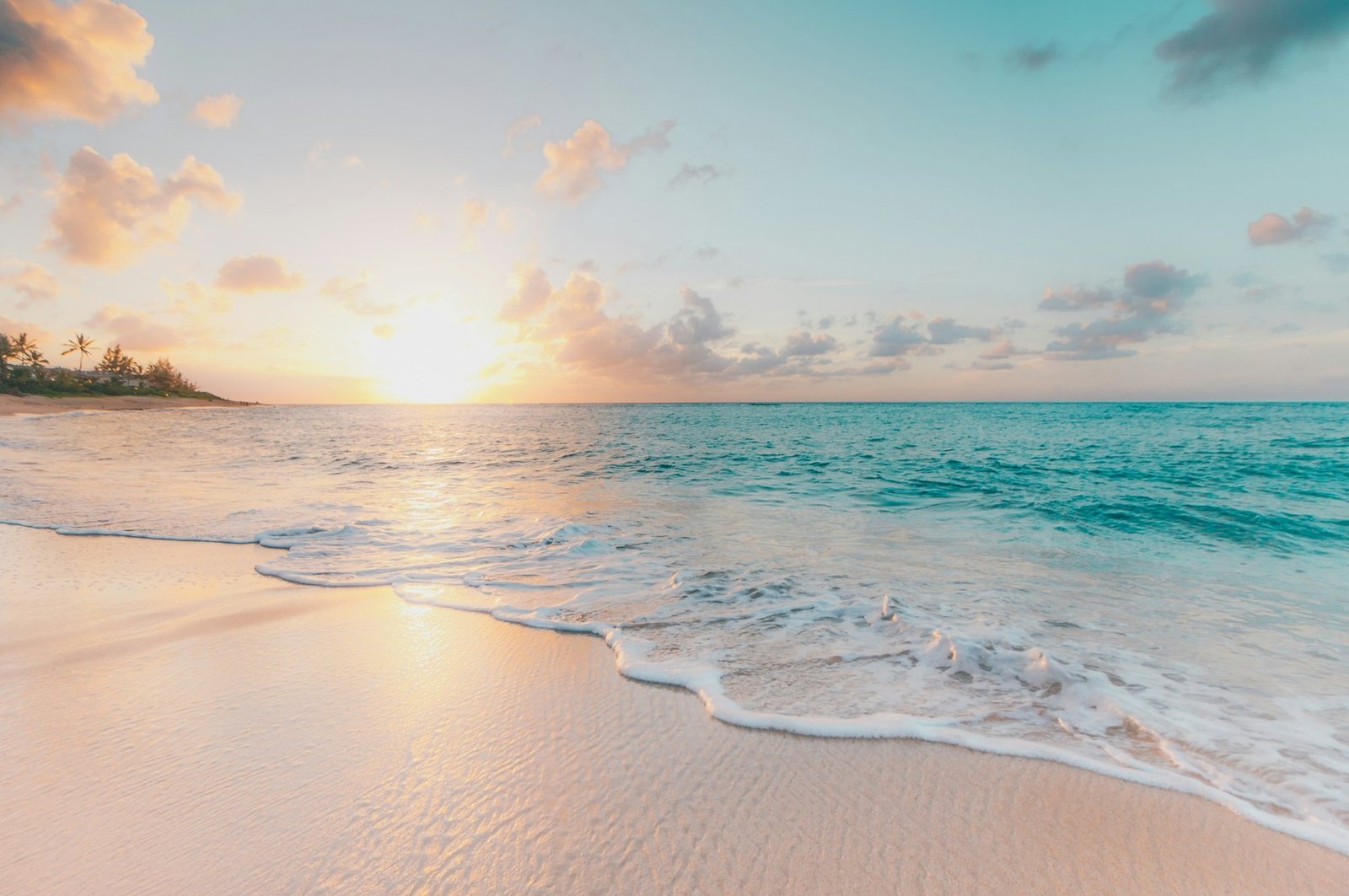 Golden Goa beach at sunset with turquoise waters and palm trees